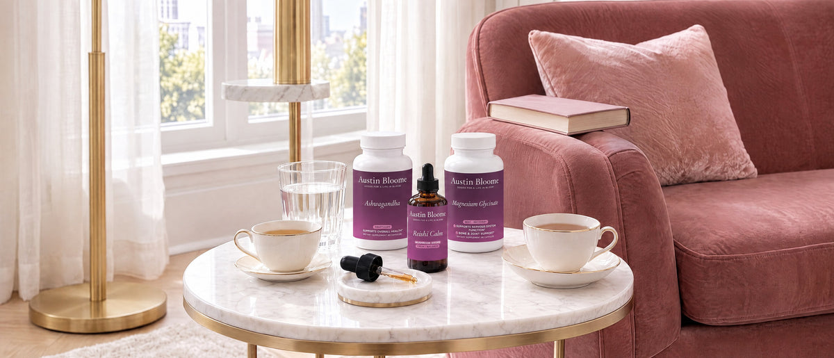 Calm Stack Ashwagandha, Reishi Calm drops and Magnesium Glycinate on a round marble side table with two teacups beside a blush velvet armchair