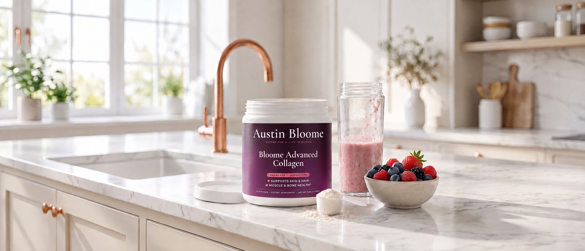 Bloome Advanced Collagen canister open with a scoop beside a smoothie on a marble kitchen counter