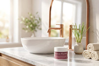 The 2 oz jar on a marble vanity in a bright bathroom with copper fittings