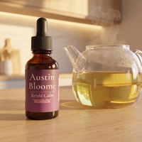 Reishi Calm Drops on a warm evening kitchen bench beside a glass teapot of herbal tea
