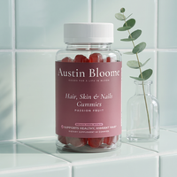 Hair, Skin & Nails Gummies on a pale tiled shelf with a eucalyptus stem