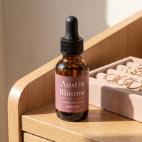Nourishing Jojoba Face Oil on a sunlit dressing table with gold hoops