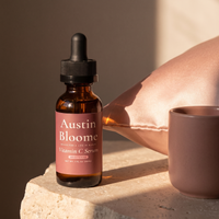 Vitamin C Serum lit by a first-light dawn beam on a stone ledge